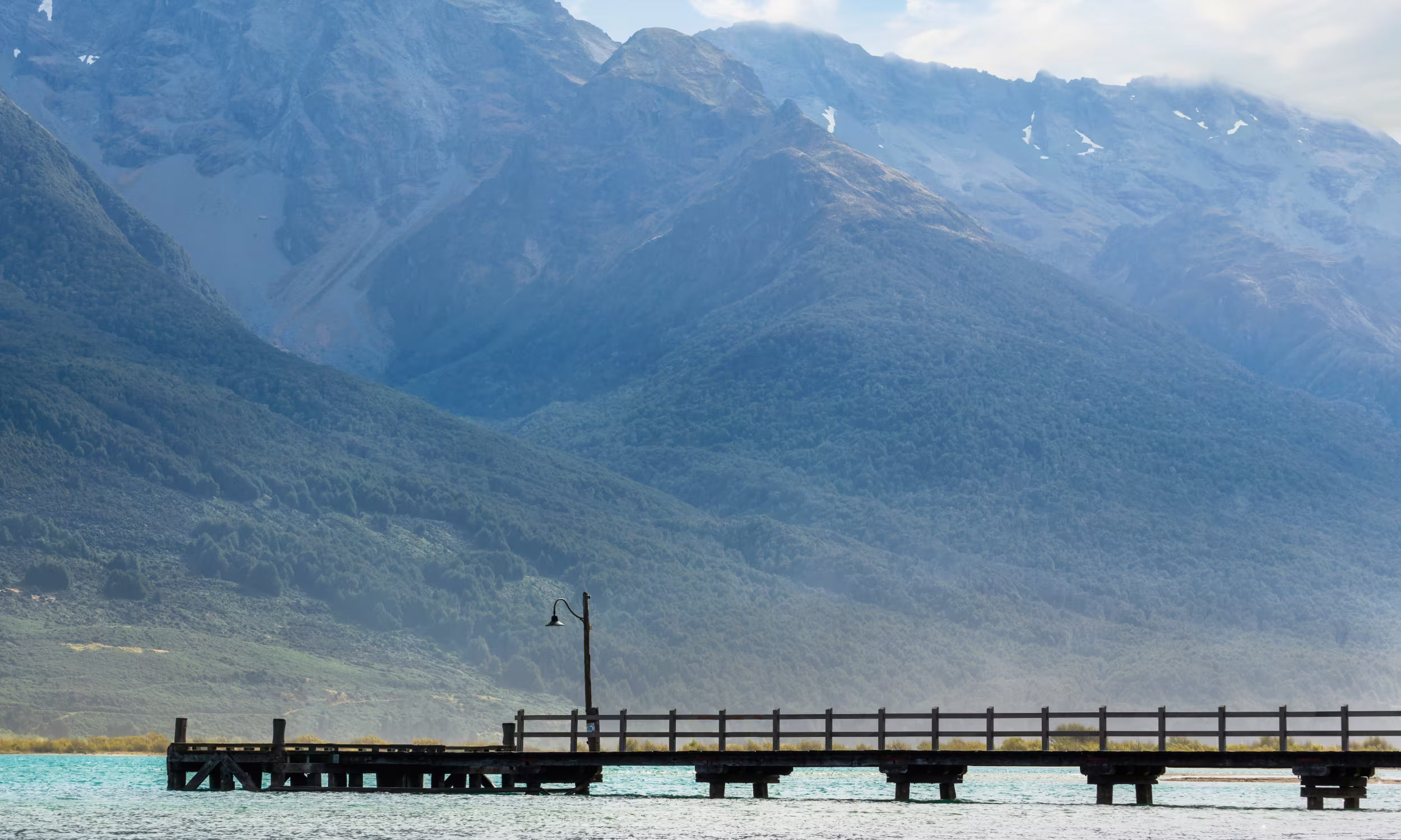 Glenorchy Pier on Lake Wakatipu surrounded by mountains in New Zealand.
