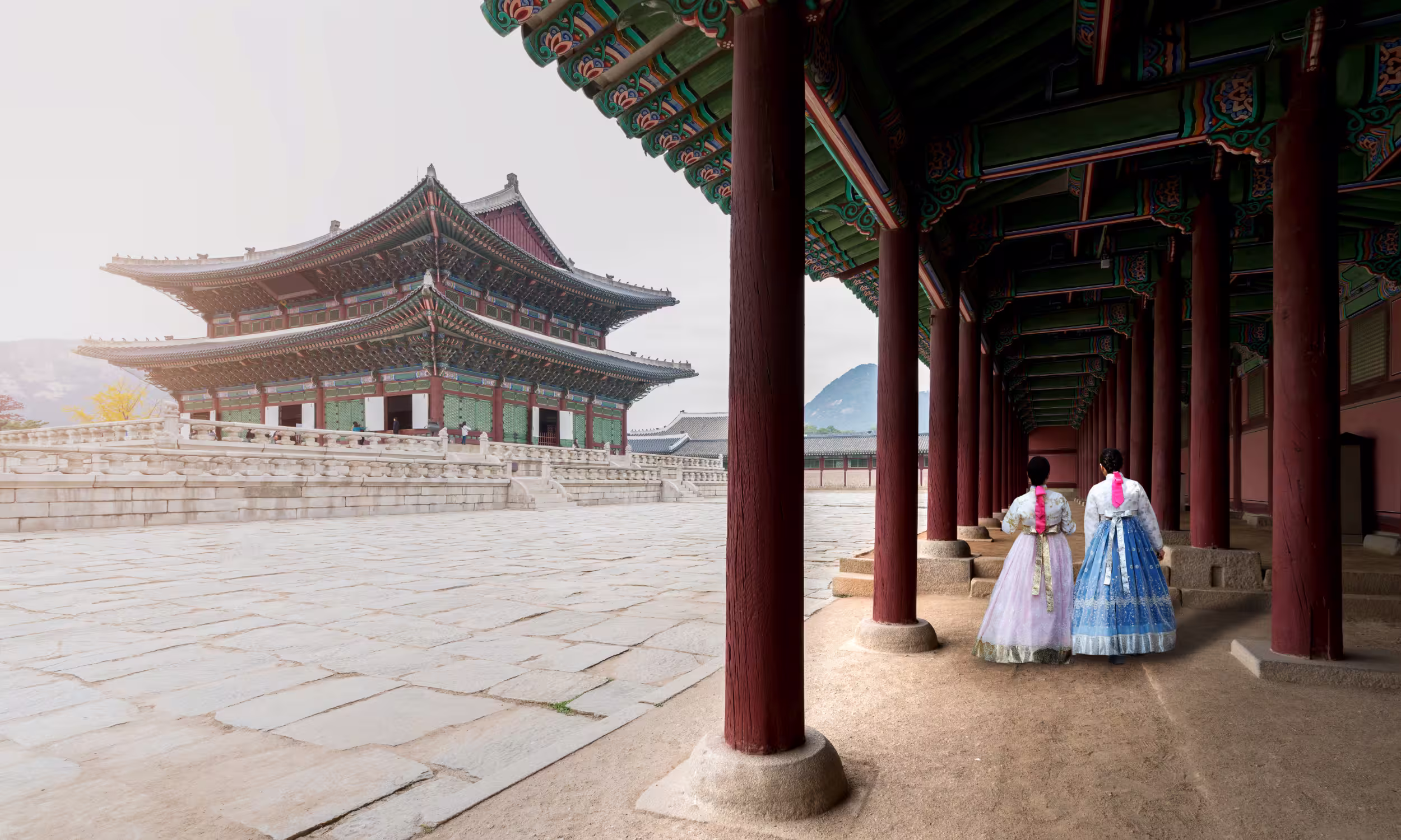 Women wearing a traditional hanbok while walking through Gyeongbokgung Palace in Seoul, South Korea.