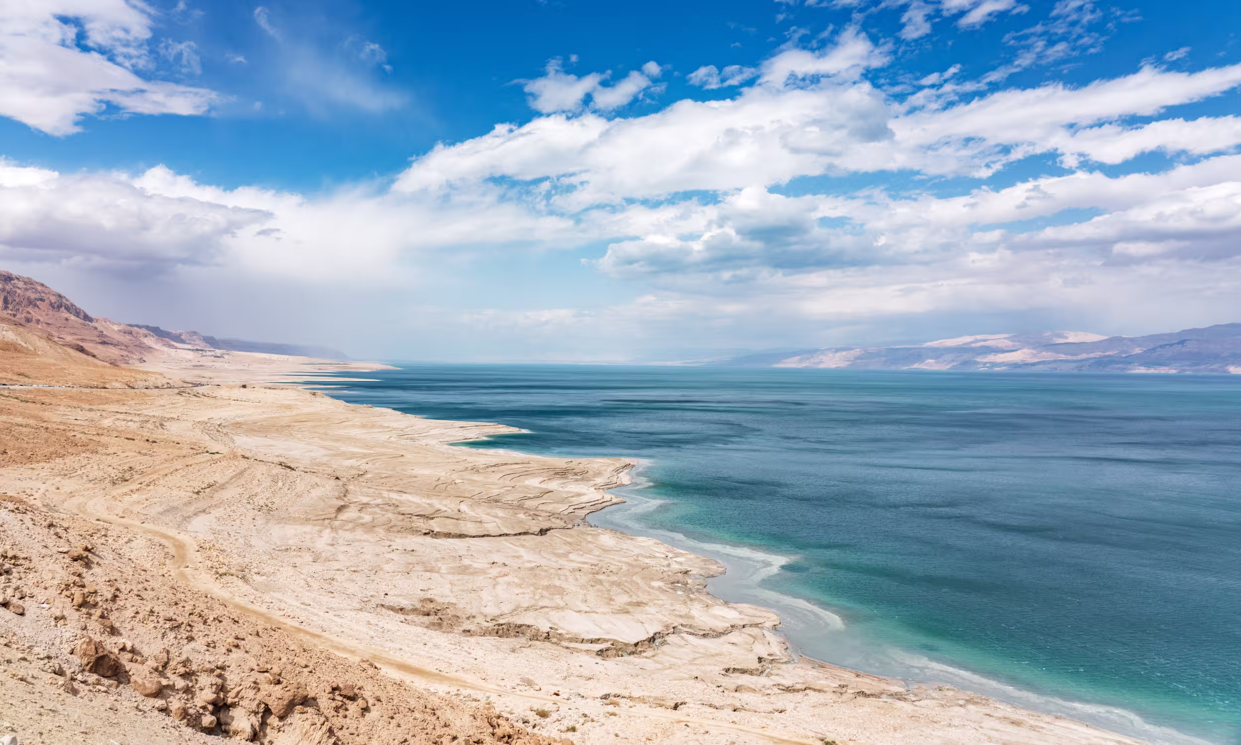 Costa do Mar Morto junto a Ein Gedi, com águas calmas e paisagem desértica em Israel.