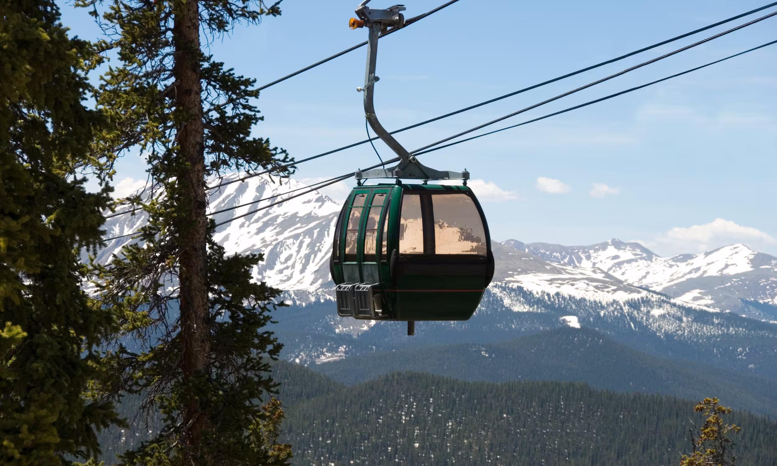 Teleférico Skyride da Grouse Mountain a subir sobre a floresta com vista para as montanhas junto a Vancouver.
