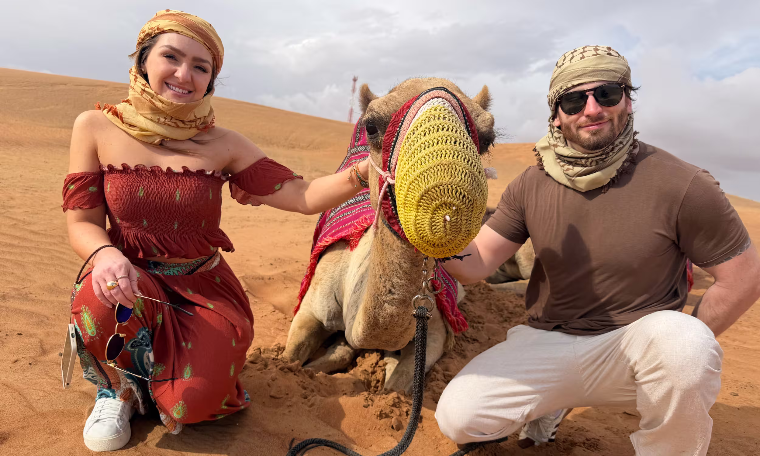 Juliana e Eduardo, casal Honeymooners, a desfrutar de uma experiência no deserto durante a lua de mel nos Emirados Árabes Unidos.