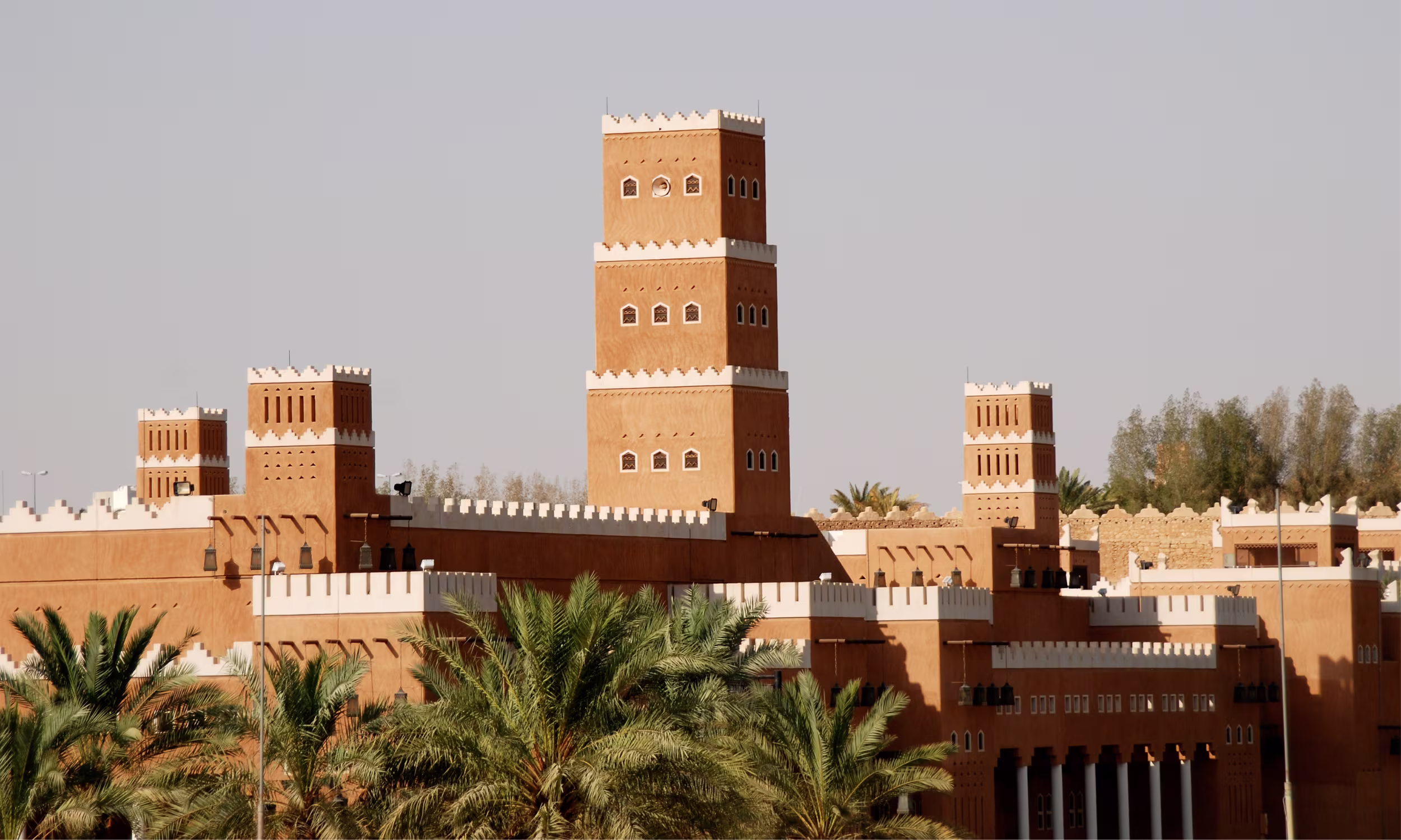 Arquitetura tradicional saudita com edifícios em tons de terra e torres características.