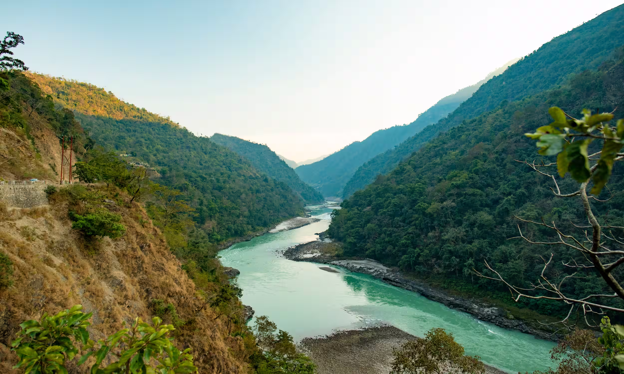 Sacred Ganges River flowing through the green mountains of Rishikesh in Uttarakhand, India.