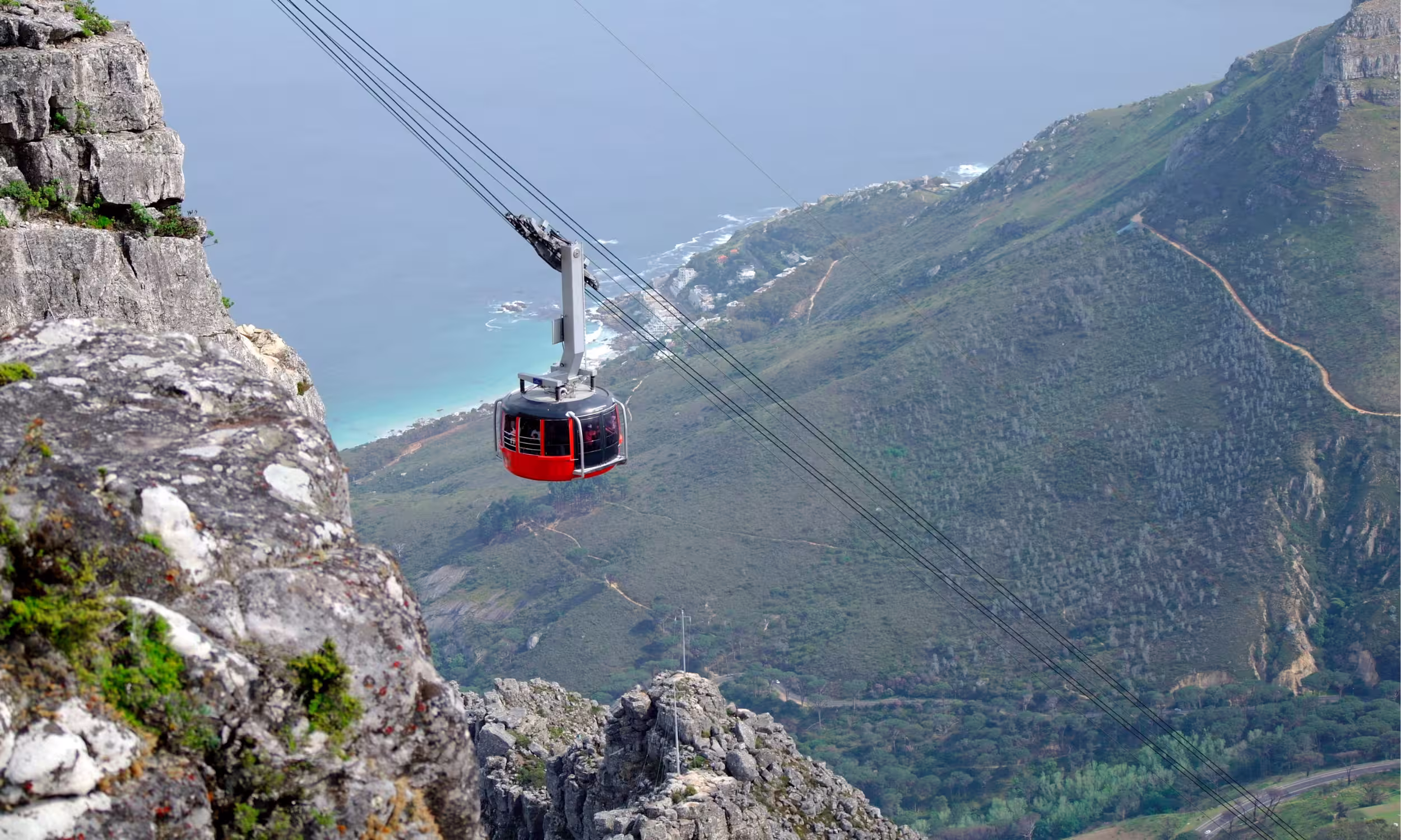 Teleférico da Table Mountain a subir sobre a paisagem montanhosa da Cidade do Cabo, na África do Sul.