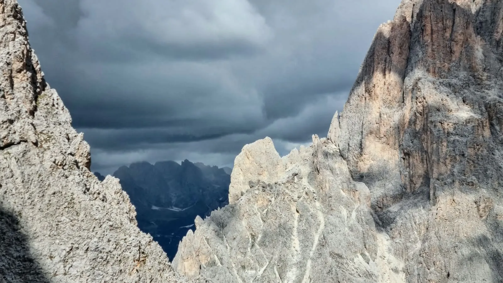 Jagged limestone towers of the Sassolungo range framing a stormy sky