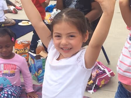 Picture of a child happy with their arms up