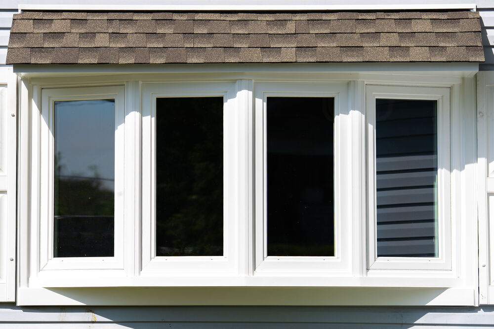 Close-up view of white-framed replacement windows with half-closed blinds