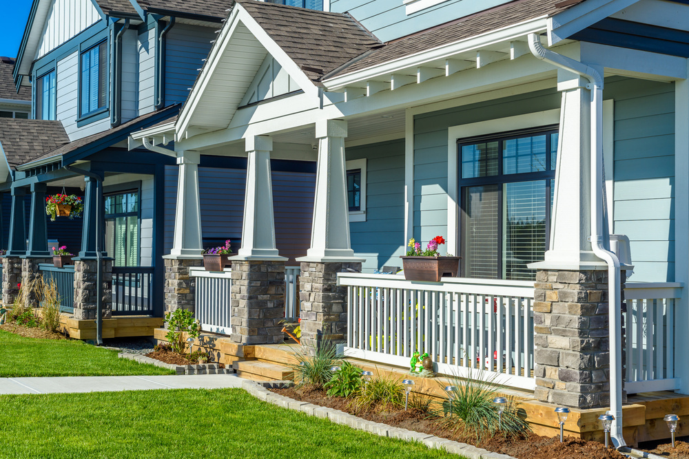 Two-story home with blue siding and white framed replacement windows