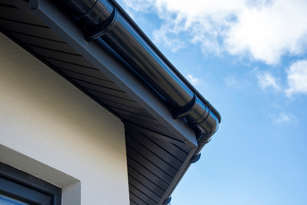 Close-up view of a black gutter and downspout