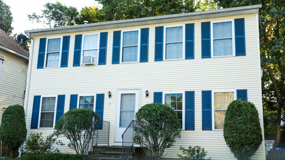 Side view of home with blue vinyl siding and windows