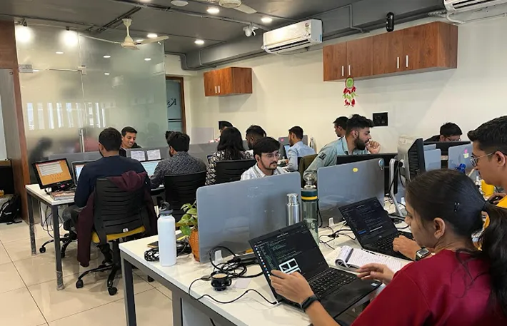 A group of people working on computers in a room.