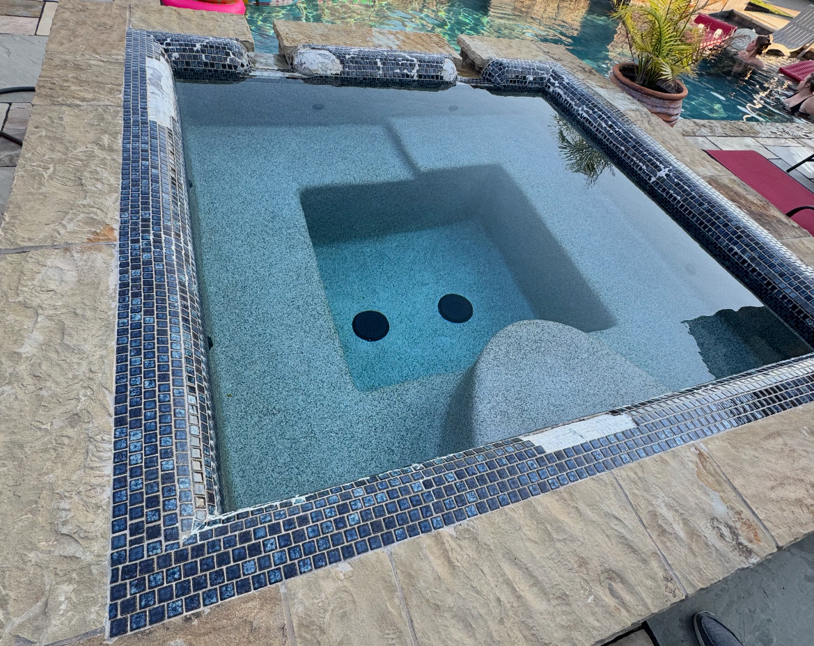 Spa before remodel with missing and damaged waterline tile