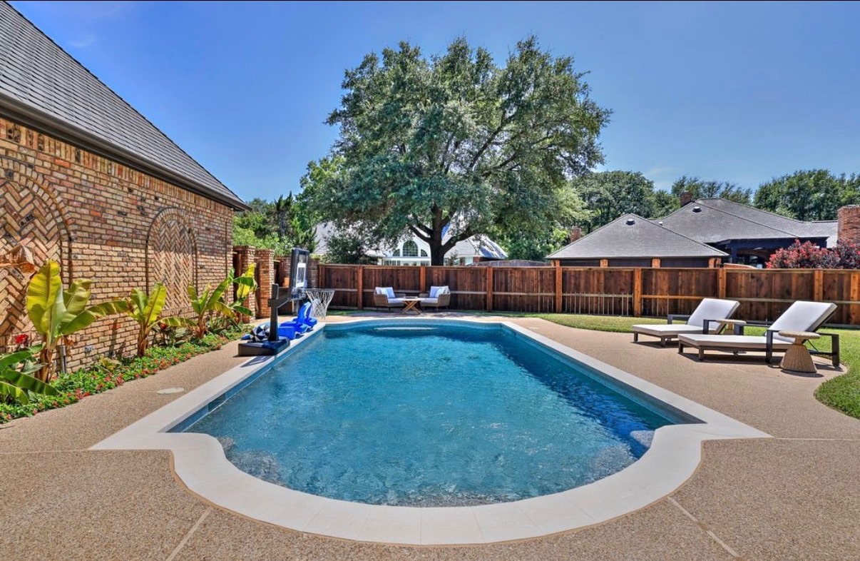 Remodeled pool with new light coping under a large oak tree