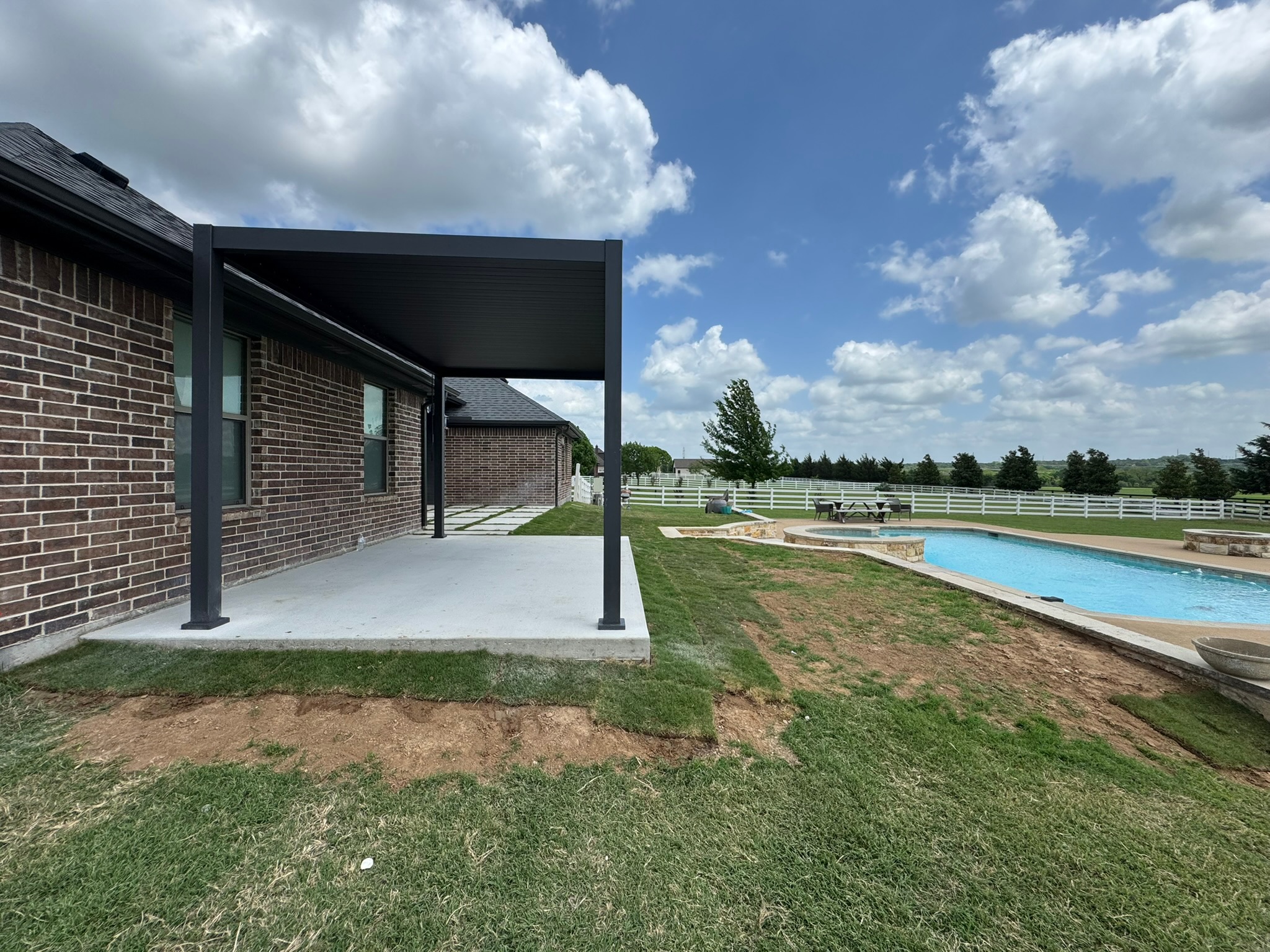 New patio slab with modern pergola beside the house