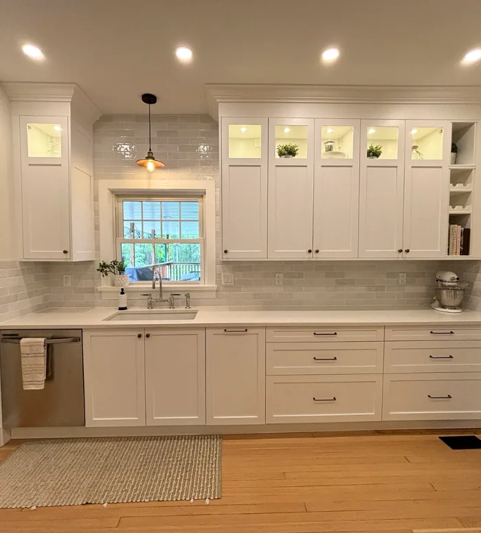 White custom IKEA kitchen with glass upper cabinets