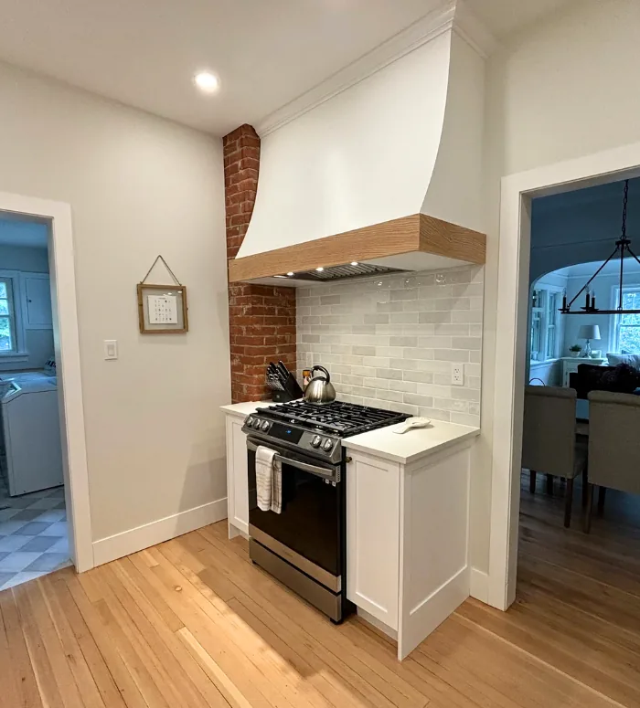 Custom range hood with wood trim over a gas range