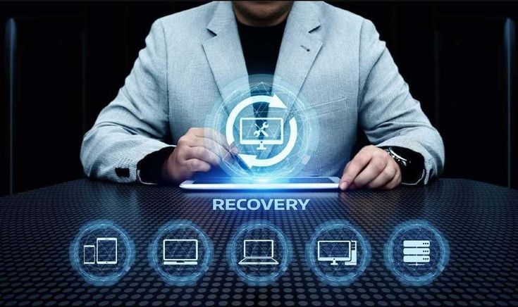 IT professional monitoring backup and recovery infrastructure on multiple screens