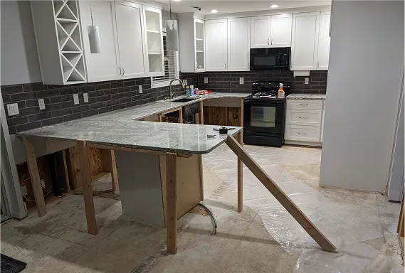 A Tacoma kitchen mid-remodel with new granite countertops held up by temporary wooden supports.