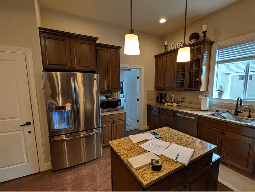 Original Bonney Lake kitchen with dark espresso cabinets, gold granite countertops, and peninsula blocking the living room view