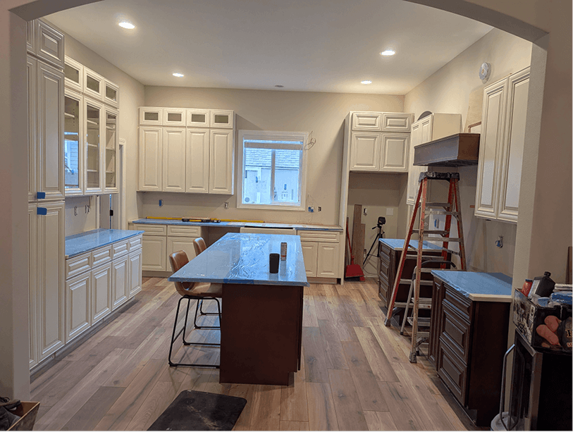 View from the living room through the arched entry showing the full two-tone cabinet layout and island