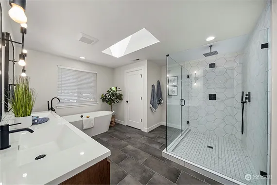 A finished bathroom remodel in Tacoma with a tiled walk-in shower, floating vanity, and matte black fixtures.