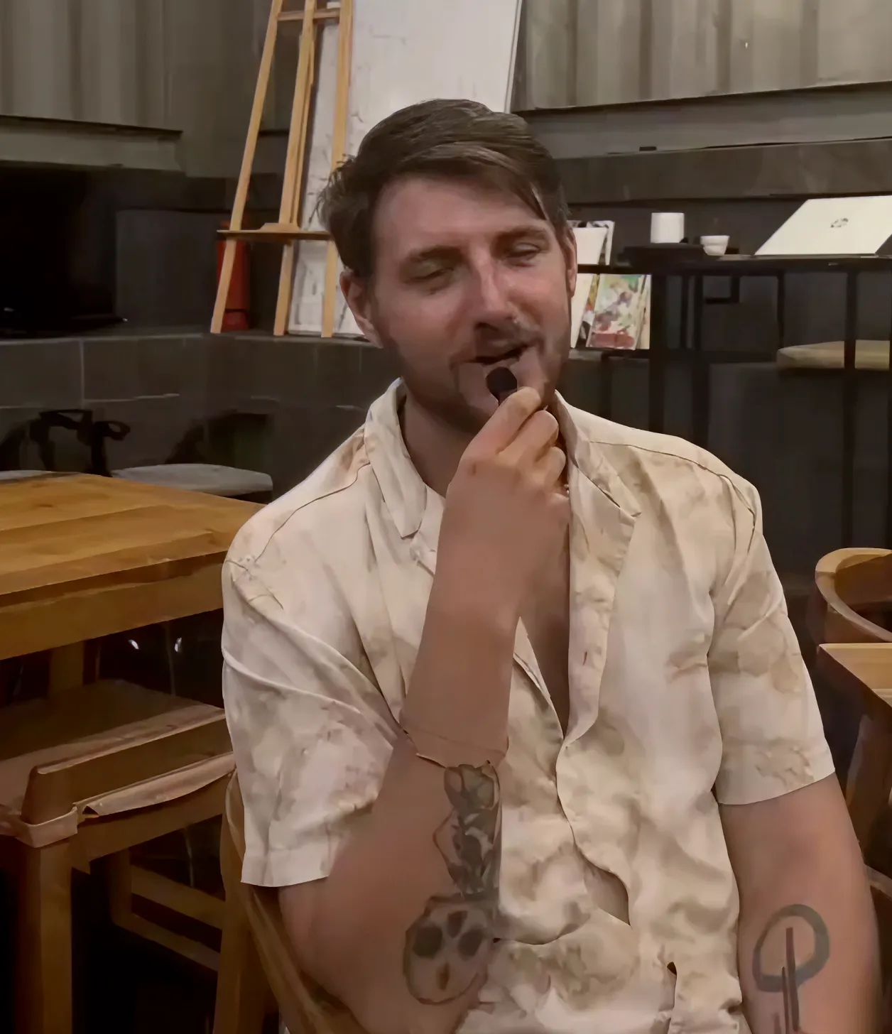 A man sitting in a chair with a tattoo on his arm.