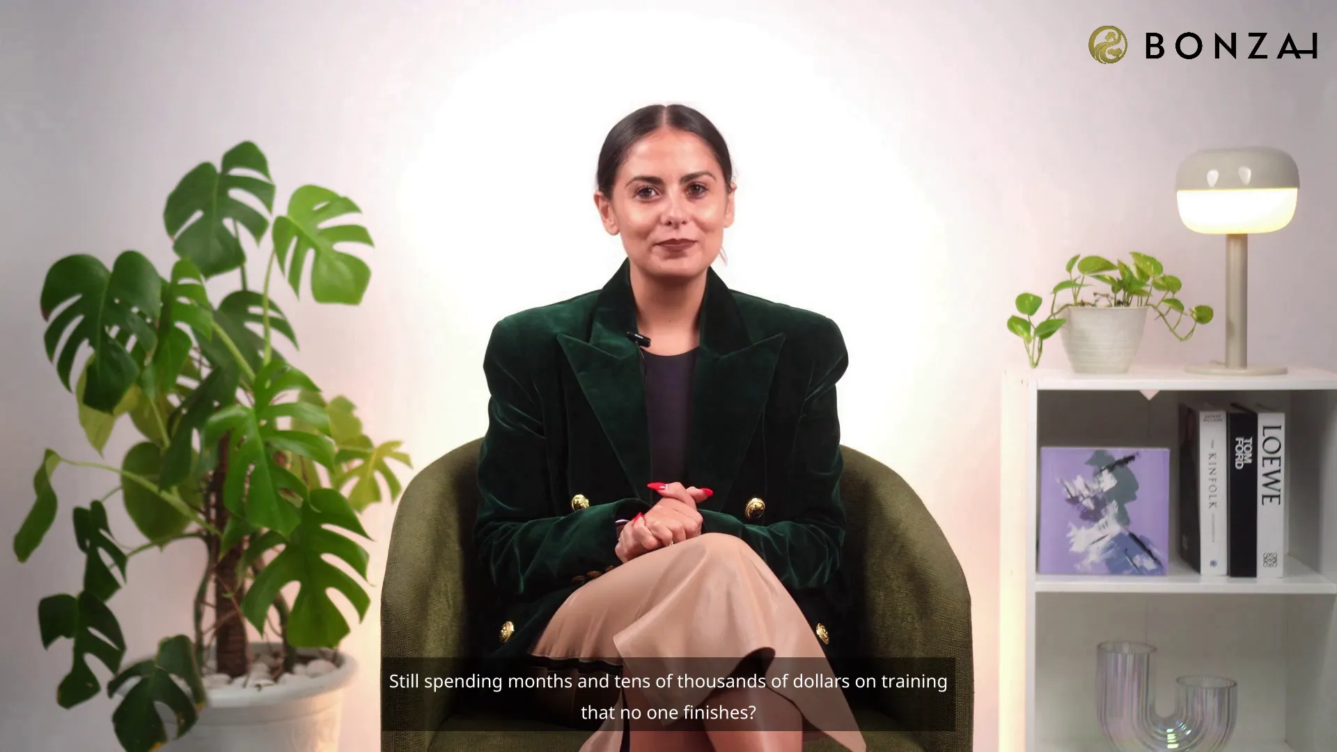 A woman sitting in a green chair in front of a potted plant.