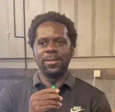 A man holding a toothbrush in his right hand.