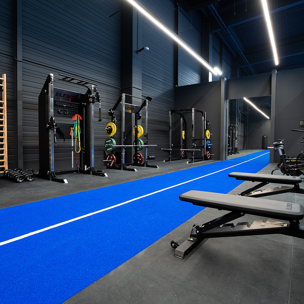 Moderna svlačionica s drvenim ormarićima i klupama te velikim ogledalom na zidu.