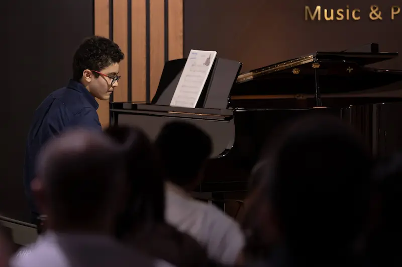 Student performing a classical piano piece during a recital