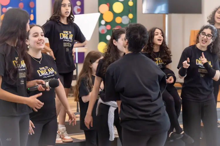 Students demonstrating acting, movement, and stage presence during a live theatre performance