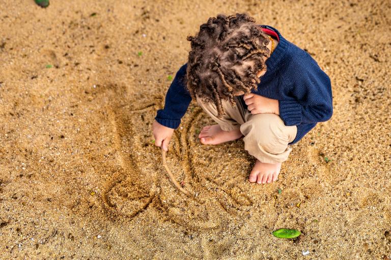 child-playing-with-sand-stick-illumine