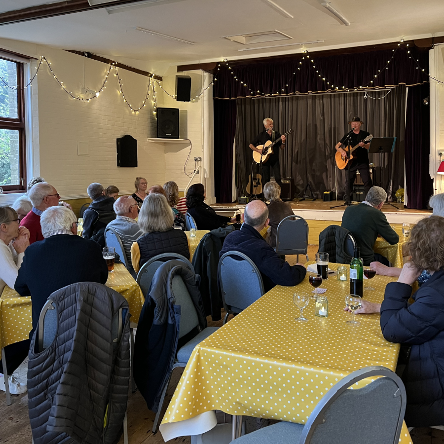 People enjoying a live music event in a village hall