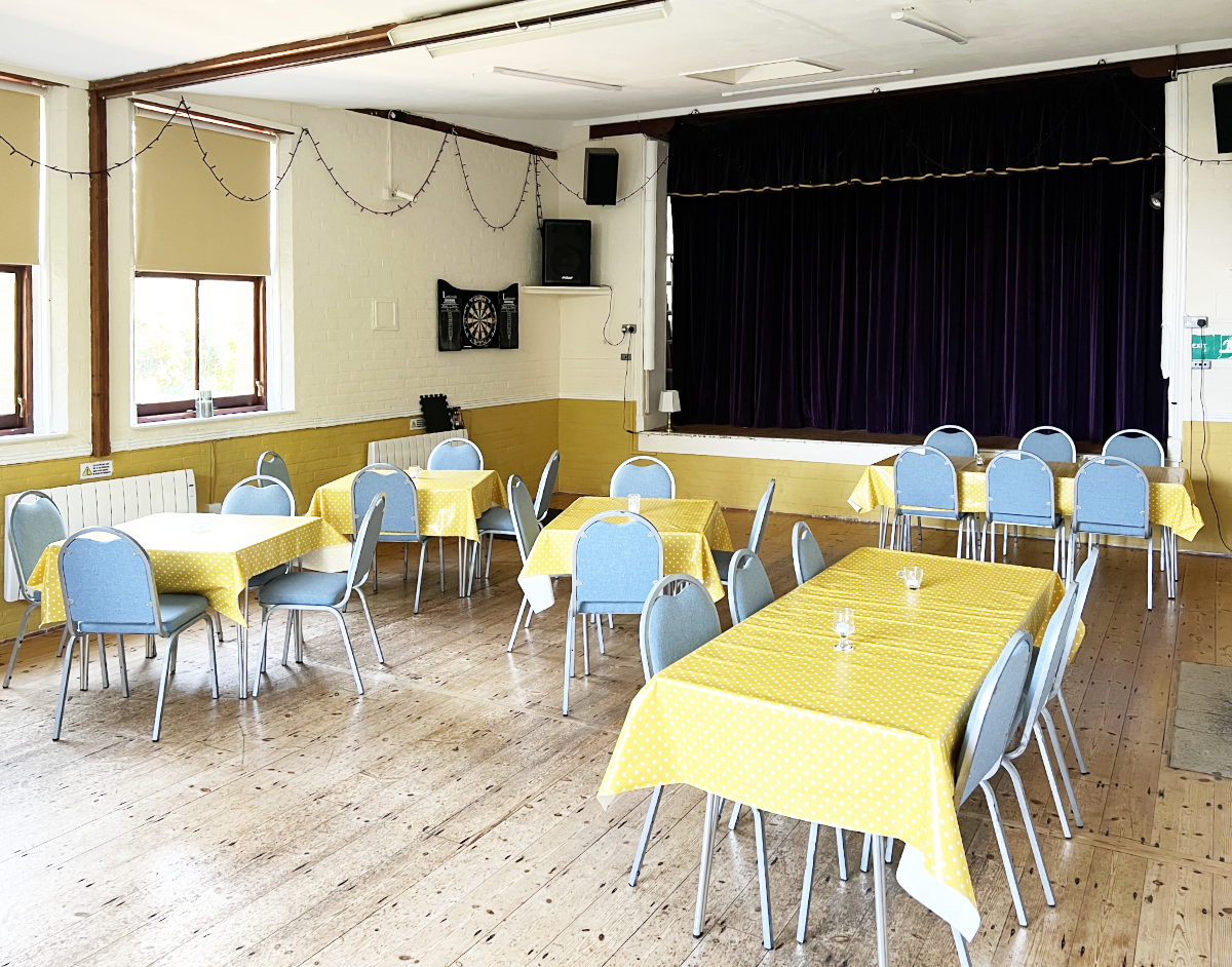 The main room in a village hall laid out with tables and chairs