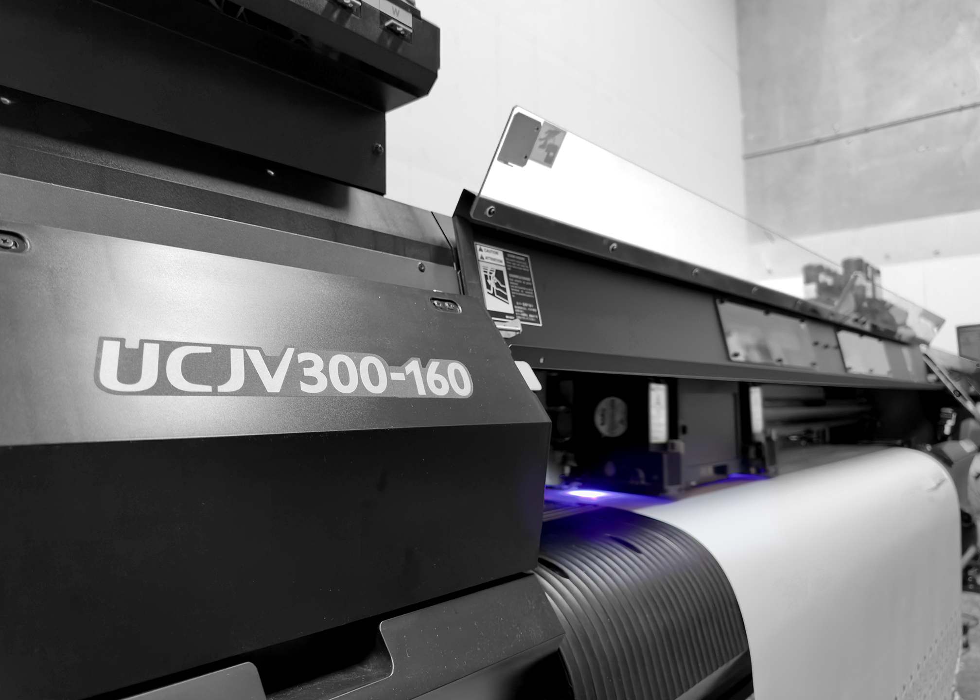 Image of the front of a Mimaki printer with the UV light on