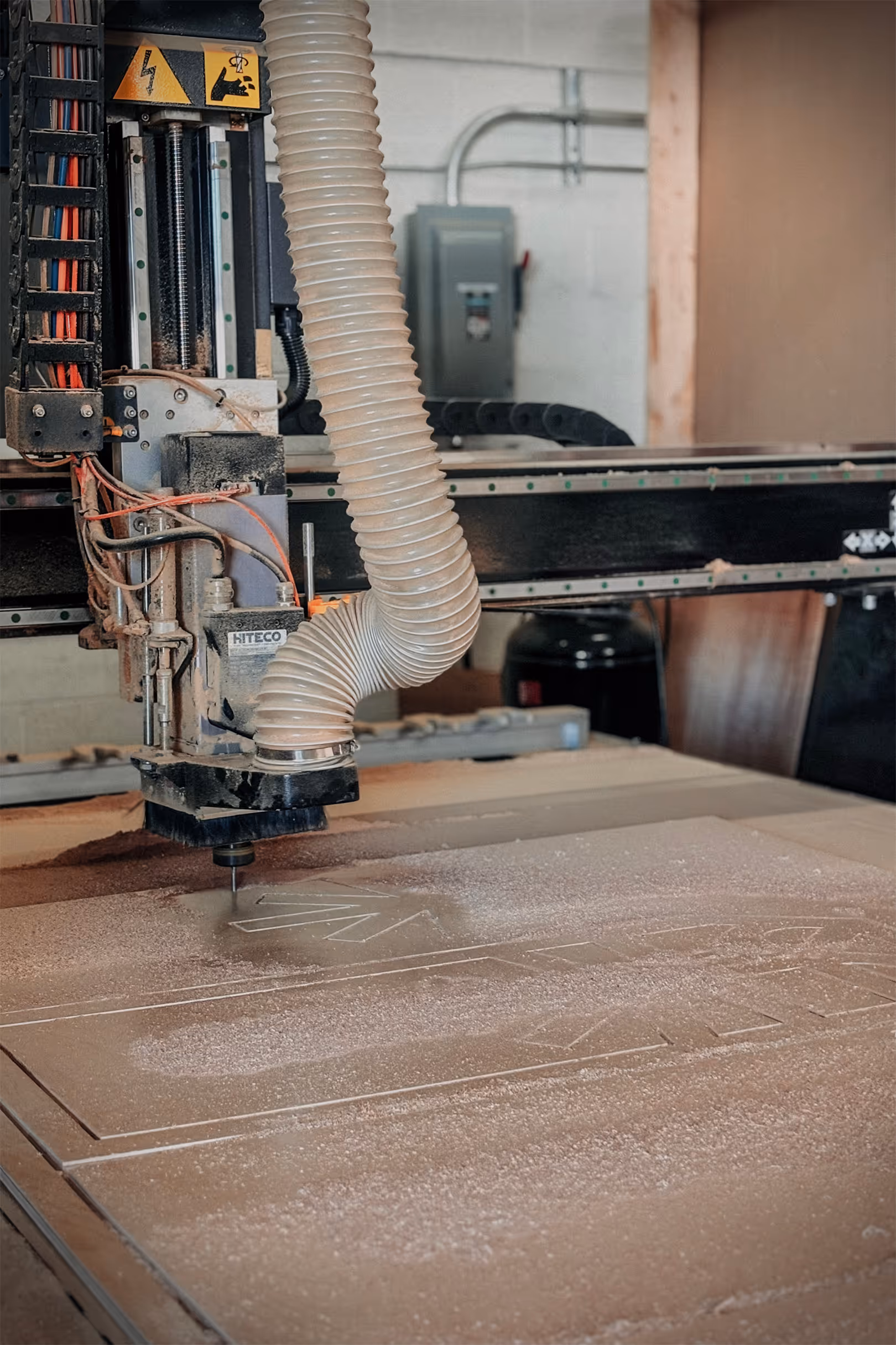 A CNC router cutting a geometric shape out of wood.