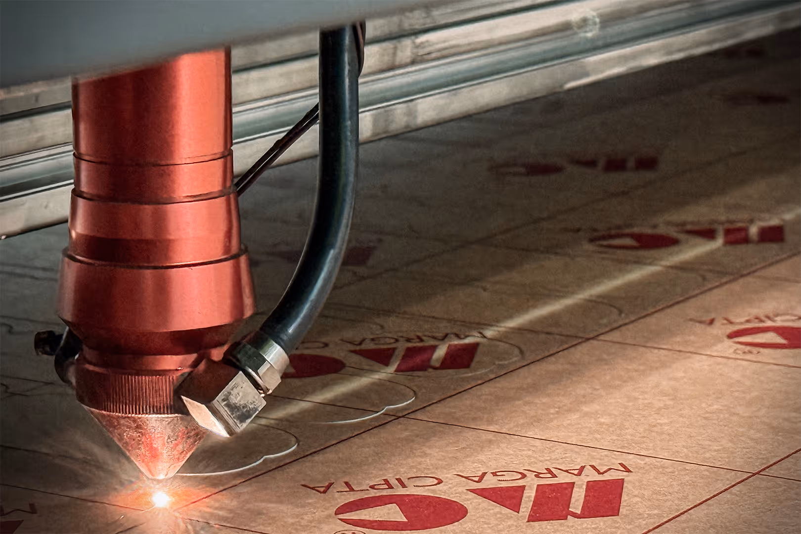 A red laser cutting through a sheet of acrylic