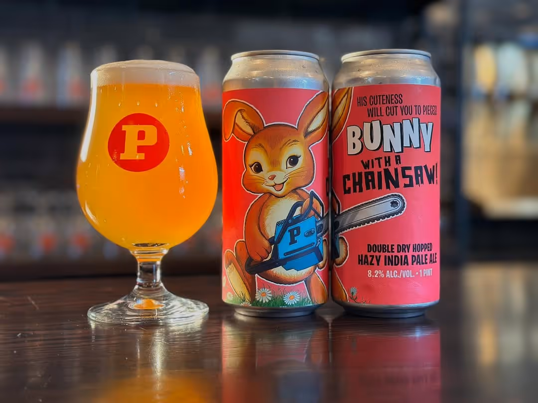 Two Paperback Baby Bunny with a Chainsaw beer cans with a glass of beer in a Paperback cup.