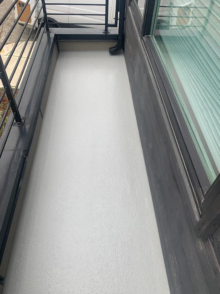 Durable, slip-resistant waterproof balcony membrane installed along a narrow exterior walkway.