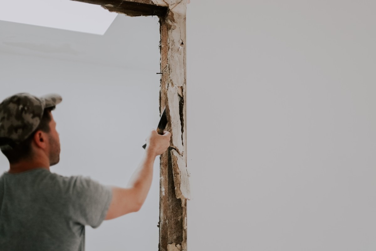 A contractor removing rot of a damaged door frame in a Bellevue home