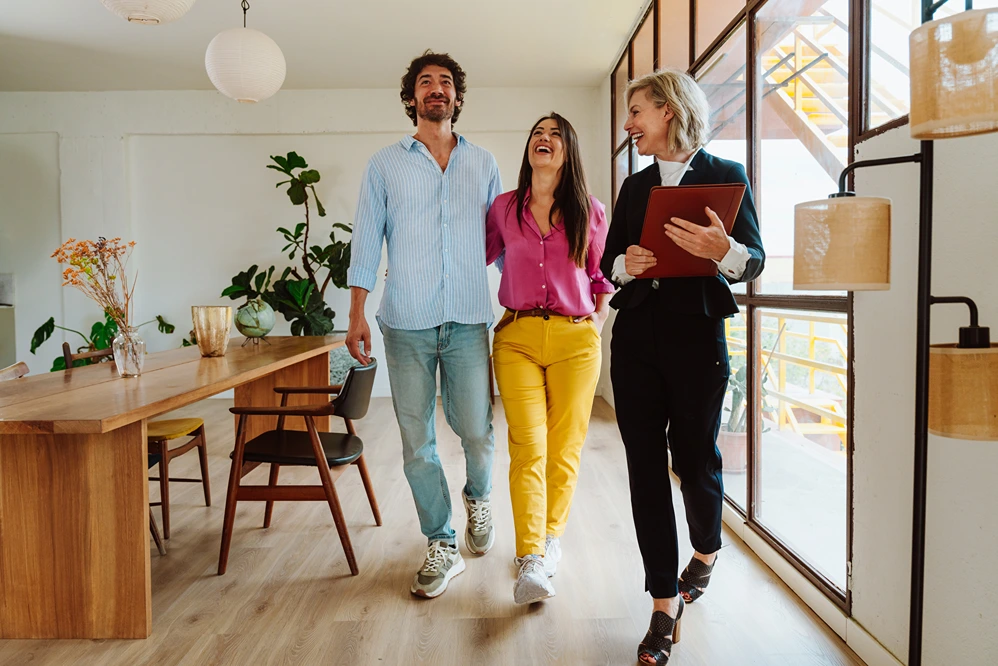 A real estate agent showing around a home to a young couple in Bellevue