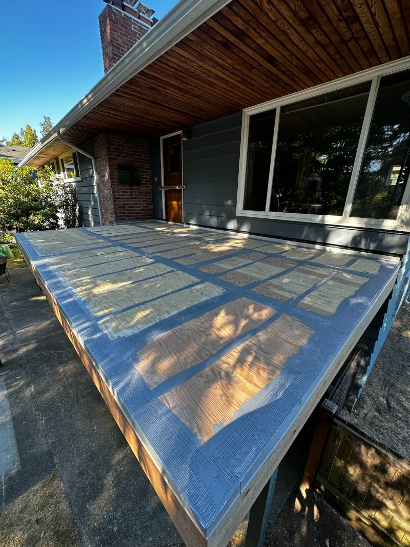 Damaged residential deck covered with blue tarps awaiting dry rot repair in Shoreline WA