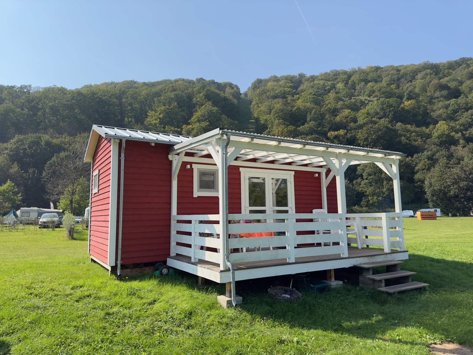 Mobilheim 9 in Rot mit weißer Pergola und Terrasse