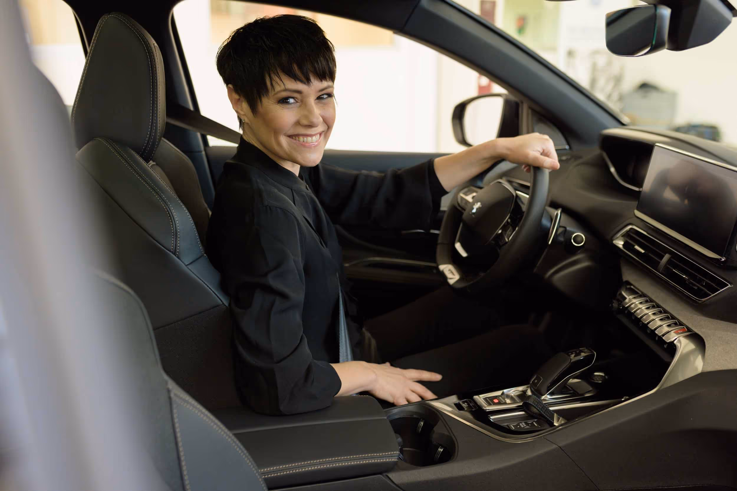 Francine Jordi sits in a car and smiles.