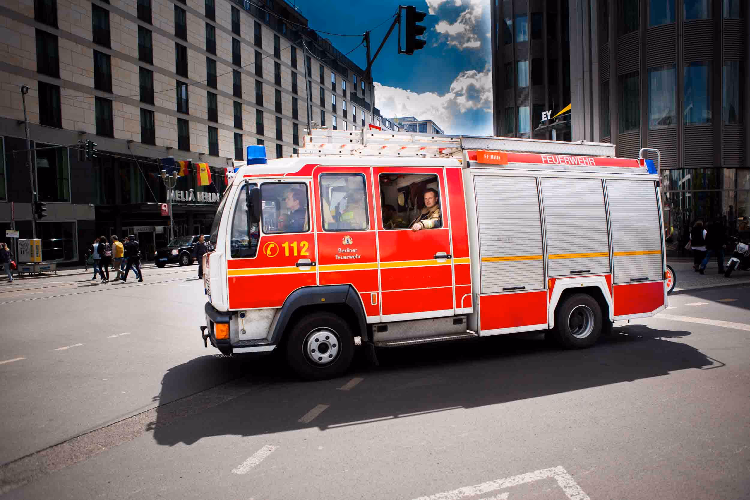 A red fire engine drives along a road.