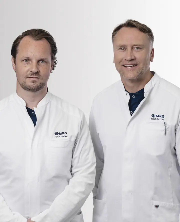 Dr. Dr. Johannes Scholz und PD Dr. Dr. Matthias Zirk in weißen Praxisjacken