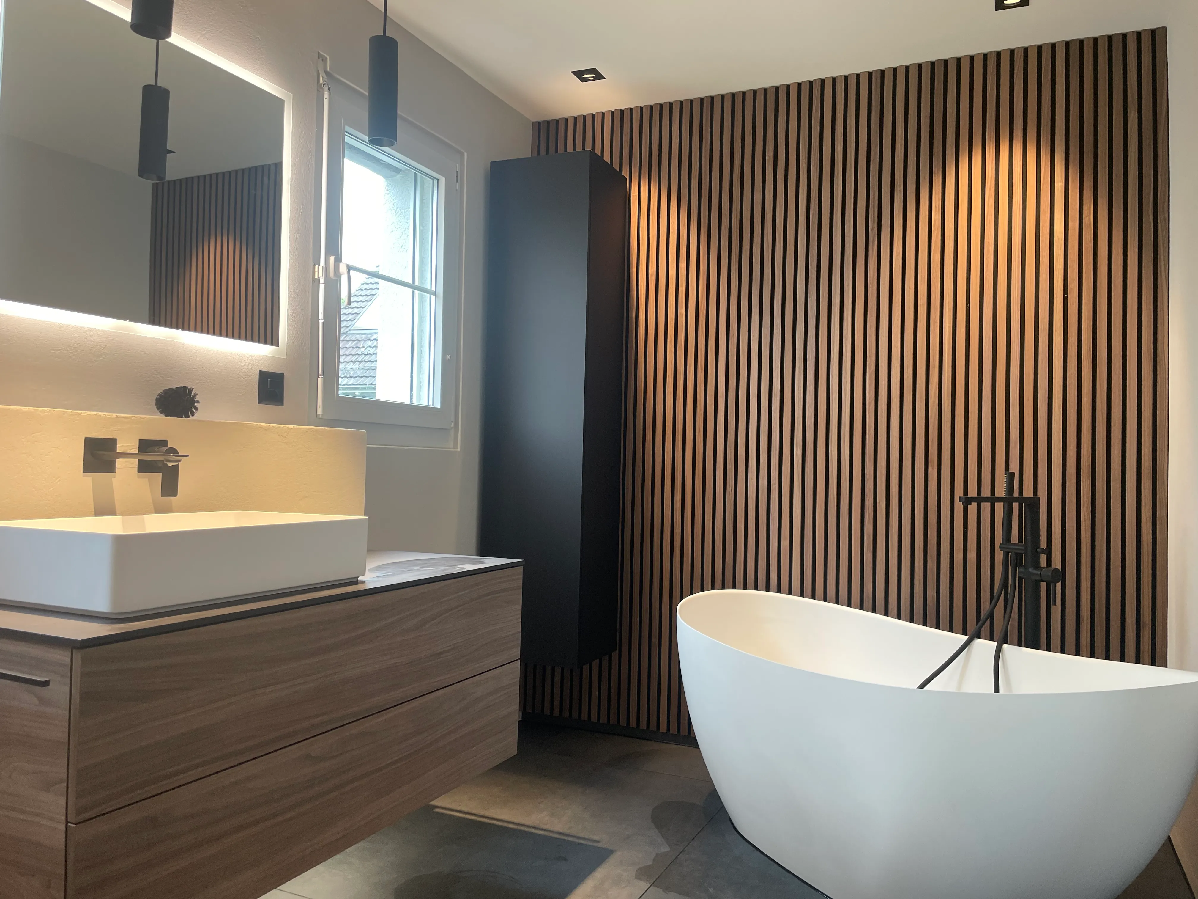 Badezimmer mit HOlzwand und Badewanne