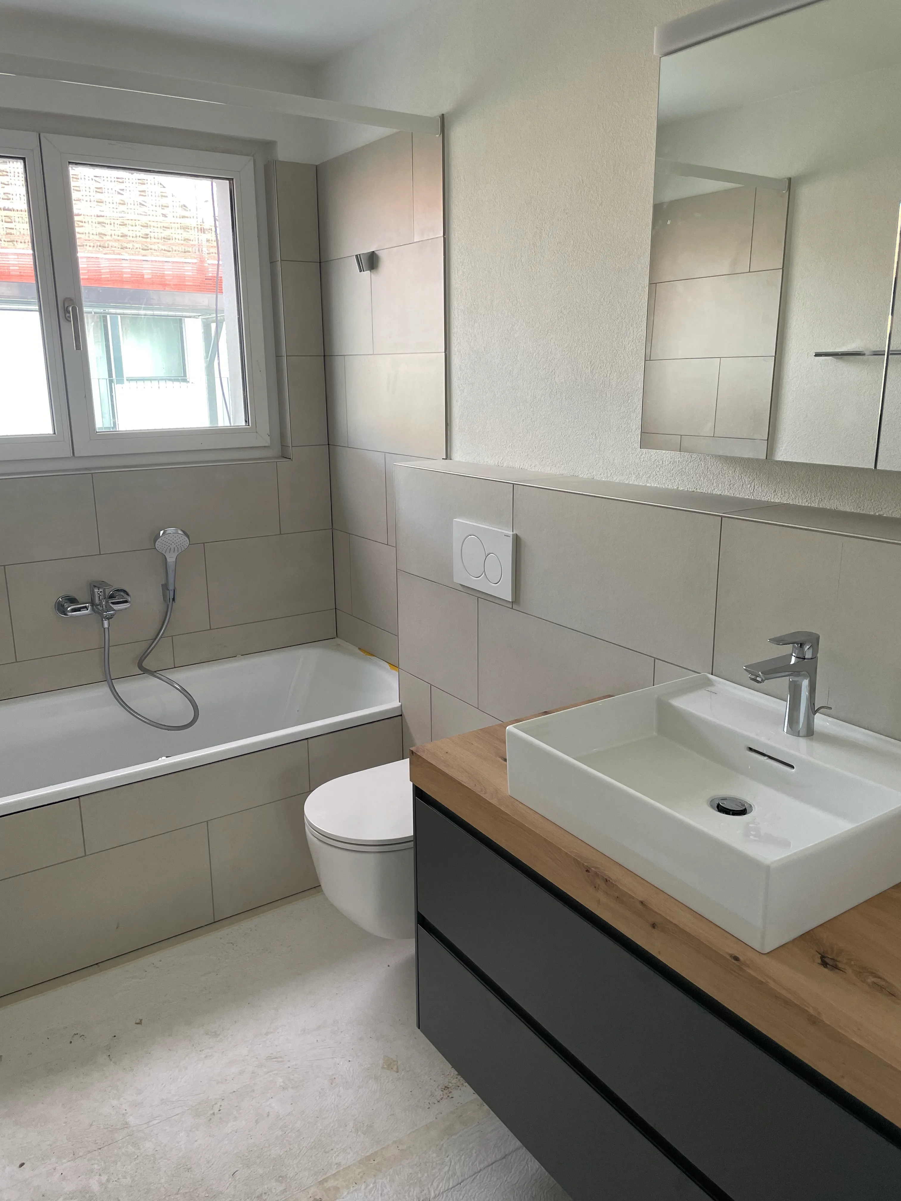 Badezimmer mit Badewanne, Spiegelkasten und Lavabo