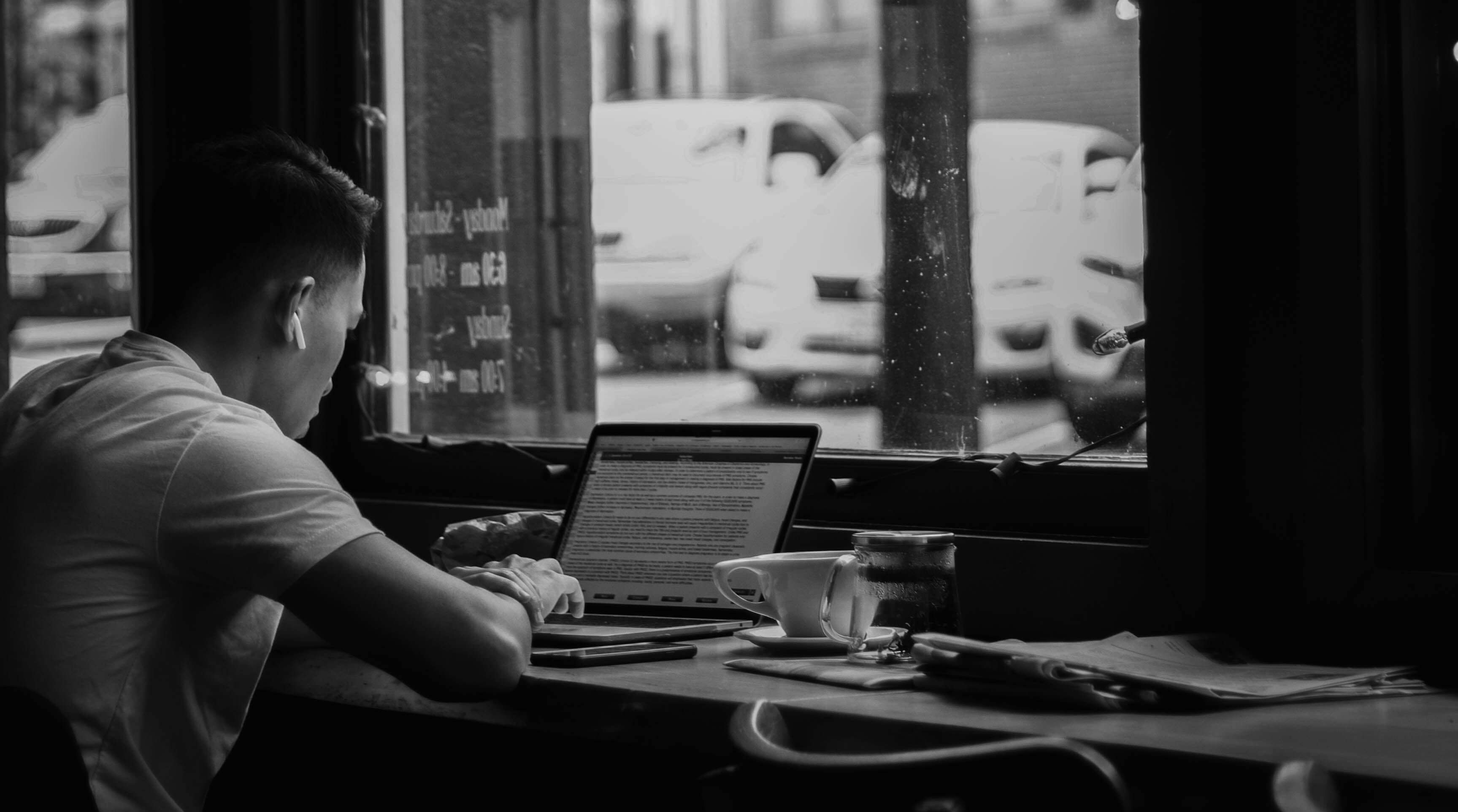 man working on laptop near window - AI Assessment Tools