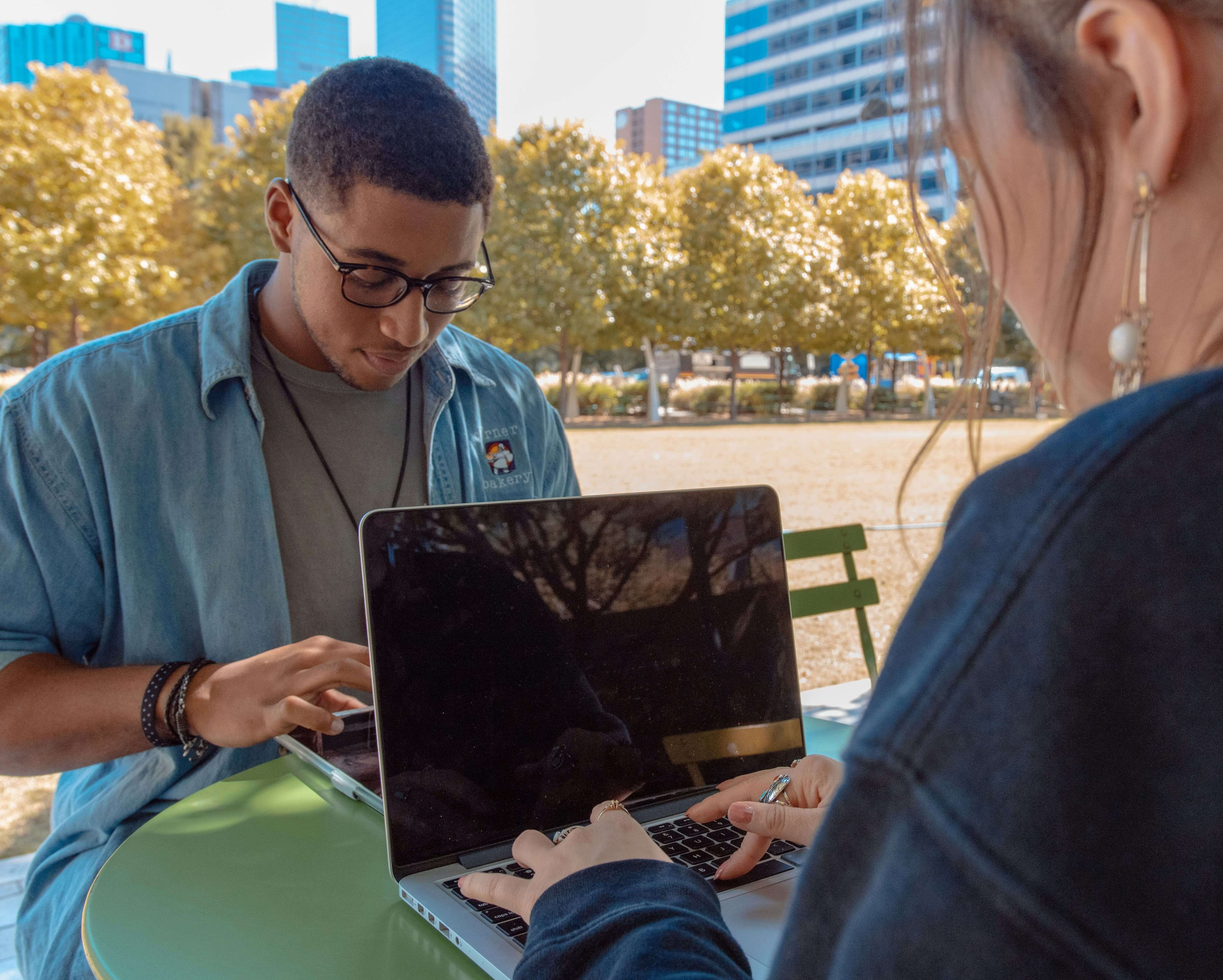 students working on their laptops in a park - Formative vs Summative Assessment
